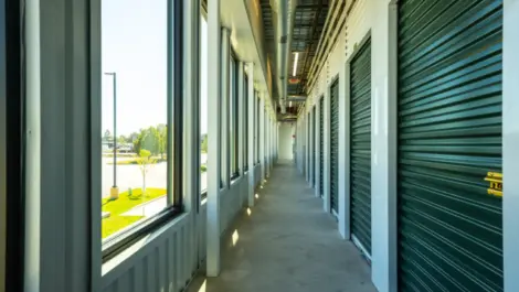 Indoor storage units, green doors with lock and window view Towne Storage-Clinton