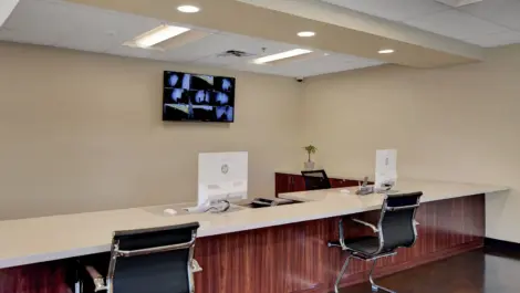 Office area, seating area, with tv and security footage on the wall at Towne Storage Sunset