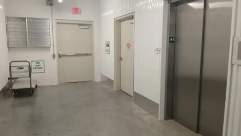 Elevator doors and a dolley inside a storage facility